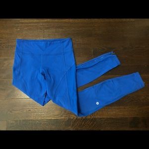 Bright blue lululemon mid-waisted full length leggings with side pockets and zip